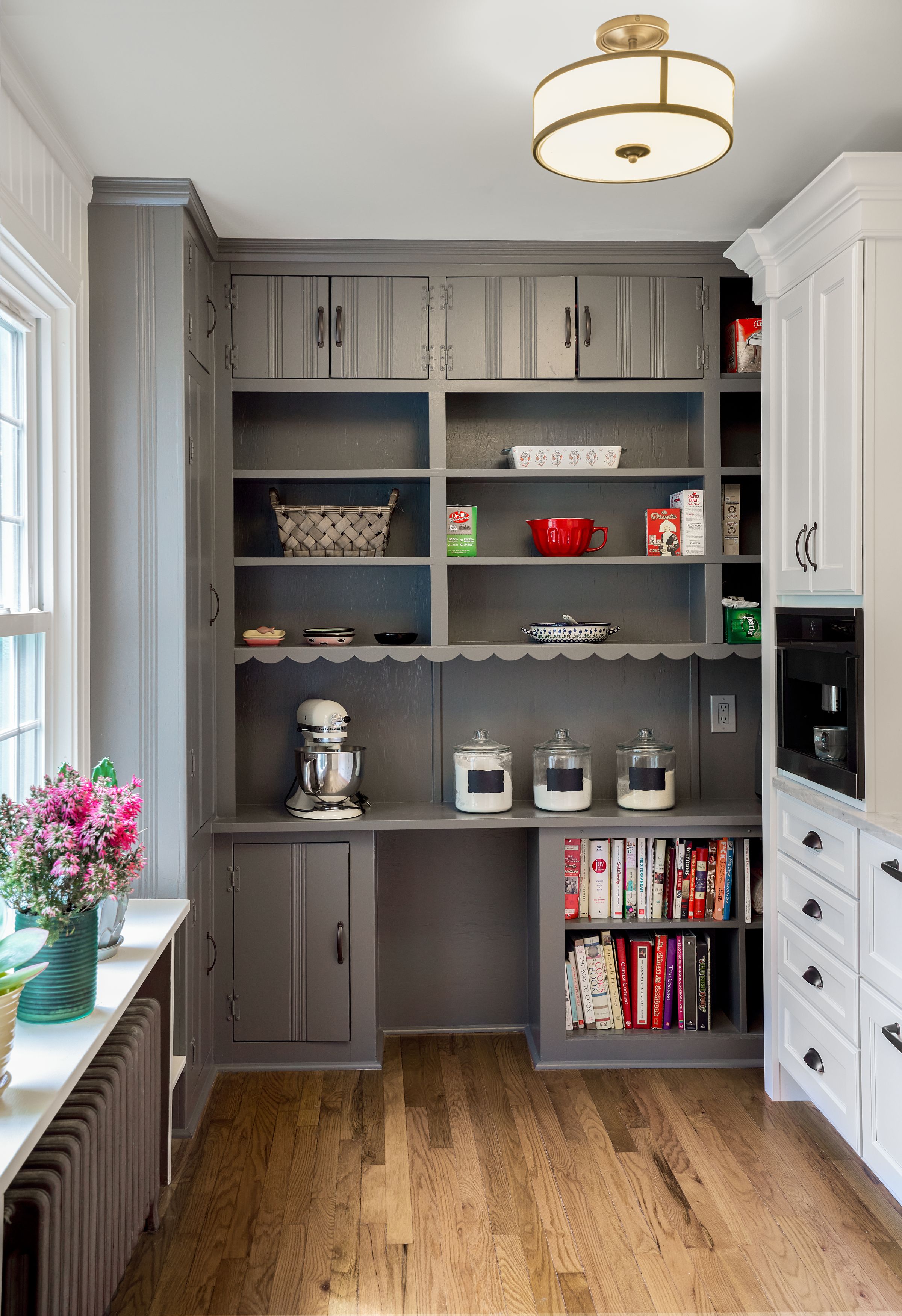 A kitchen pantry with gray built-in cabinets, open shelving, a white stand mixer, and a white cabinet with a coffee maker.